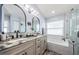 Luxurious bathroom with dual sinks, marble countertops, a soaking tub, and a separate glass-enclosed shower at 382 Tavernier Cir, Oldsmar, FL 34677