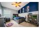 Stylized bedroom featuring a bold blue accent wall, ceiling fan, and themed decor at 382 Tavernier Cir, Oldsmar, FL 34677