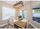 Well-lit dining area features modern lighting, backyard views, and neutral decor at 382 Tavernier Cir, Oldsmar, FL 34677