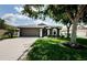 Single-story home with a two-car garage, green lawn, and well-manicured landscaping at 382 Tavernier Cir, Oldsmar, FL 34677