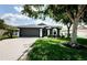 Lovely front exterior features a well-kept lawn, mature trees, and an attached two-car garage at 382 Tavernier Cir, Oldsmar, FL 34677