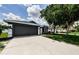 Beautiful house featuring an attached garage, a well-maintained lawn, and mature trees at 382 Tavernier Cir, Oldsmar, FL 34677