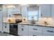 Contemporary kitchen features white cabinets, stone countertops, and stainless steel appliances at 382 Tavernier Cir, Oldsmar, FL 34677