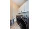 Convenient laundry area with wood-look tile floors, and dark front-load washer and dryer at 382 Tavernier Cir, Oldsmar, FL 34677