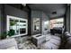 Well-lit screened patio features a modern ceiling fan and a sleek fire pit coffee table at 382 Tavernier Cir, Oldsmar, FL 34677