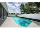 A swimming pool surrounded by a concrete deck, a white fence and green grass at 382 Tavernier Cir, Oldsmar, FL 34677