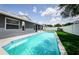 A swimming pool surrounded by a concrete deck, a white fence and green grass at 382 Tavernier Cir, Oldsmar, FL 34677