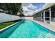 A long swimming pool surrounded by a white fence and green grass at 382 Tavernier Cir, Oldsmar, FL 34677