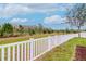 Backyard with green grass, white fence, mulch and trees at 3914 Round Table Ct, Land O Lakes, FL 34638