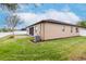View of a landscaped backyard with a screen patio, white fence, grass and tree at 3914 Round Table Ct, Land O Lakes, FL 34638
