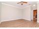 A spacious bedroom featuring wood floors, crown molding, a ceiling fan, and an ensuite bathroom at 3914 Round Table Ct, Land O Lakes, FL 34638