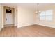 Dining room with tile entry way and modern wood floors leading to a window with chandelier lighting at 3914 Round Table Ct, Land O Lakes, FL 34638