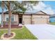 Well-maintained house with stone accents, a three-car garage, and manicured front yard at 3914 Round Table Ct, Land O Lakes, FL 34638