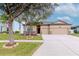 Charming home showcasing a well-kept lawn, three-car garage, and tasteful landscaping for curb appeal at 3914 Round Table Ct, Land O Lakes, FL 34638