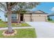 Attractive home featuring a three-car garage, manicured lawn, and decorative stone accents enhancing its appeal at 3914 Round Table Ct, Land O Lakes, FL 34638