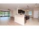 Open-concept kitchen featuring stainless steel appliances, breakfast bar, and access to the screened porch at 3914 Round Table Ct, Land O Lakes, FL 34638