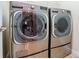 Modern laundry room with front loading washer and dryer and wire shelf at 3914 Round Table Ct, Land O Lakes, FL 34638