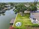 Backyard featuring a verdant lawn, fire pit, waterfront access, mature trees, and a waterfront dock at 3922 Fontainebleau Dr, Tampa, FL 33634