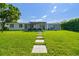 Beautiful backyard featuring stone pathways, a covered patio, and a large green lawn ideal for outdoor enjoyment at 3922 Fontainebleau Dr, Tampa, FL 33634