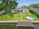 The backyard includes a green lawn, fire pit, and a waterfront dock at 3922 Fontainebleau Dr, Tampa, FL 33634