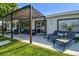 Backyard patio with modern patio furniture with a grassy lawn and view of the exterior of the house at 3922 Fontainebleau Dr, Tampa, FL 33634