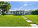 Well-manicured backyard with stone pathway leading to a patio and a lush green lawn perfect for relaxing at 3922 Fontainebleau Dr, Tampa, FL 33634
