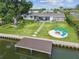 Waterfront backyard featuring a dock, fire pit, hammock, stepping stones, and patio seating area, perfect for outdoor relaxation at 3922 Fontainebleau Dr, Tampa, FL 33634
