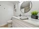 Bathroom featuring a white vanity with a modern sink, round mirror, and sleek fixtures at 3922 Fontainebleau Dr, Tampa, FL 33634
