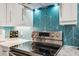 Modern kitchen features a stainless steel range with a stunning turquoise geometric backsplash at 3922 Fontainebleau Dr, Tampa, FL 33634