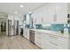 Well-lit kitchen showcasing white cabinets, stainless steel appliances, and blue backsplash at 3922 Fontainebleau Dr, Tampa, FL 33634