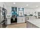 Modern kitchen with white cabinets, stainless steel appliances, and an eye-catching blue backsplash at 3922 Fontainebleau Dr, Tampa, FL 33634