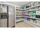 Well-stocked pantry with wood-look floors, stainless steel refrigerator and plenty of shelving for storage at 3922 Fontainebleau Dr, Tampa, FL 33634