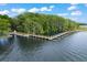 Aerial view showcasing a long wooden pier extending into a serene lake at 4063 Ligustrum Dr, Palm Harbor, FL 34685