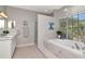 Bathroom featuring a large tub, glass shower and double sink at 4063 Ligustrum Dr, Palm Harbor, FL 34685