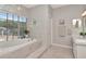 Bathroom featuring a large tub with marble surround and double sink at 4063 Ligustrum Dr, Palm Harbor, FL 34685