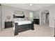 A spacious main bedroom featuring a dark wood bed frame, fan and neutral decor at 4063 Ligustrum Dr, Palm Harbor, FL 34685