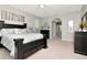 A spacious main bedroom featuring a dark wood bed frame, fan and neutral decor at 4063 Ligustrum Dr, Palm Harbor, FL 34685