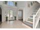Bright, open foyer with tile flooring, high ceilings, and a staircase with unique painted risers at 4063 Ligustrum Dr, Palm Harbor, FL 34685