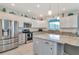 Bright kitchen featuring granite counters, stainless appliances, and white cabinets, and large center island at 4063 Ligustrum Dr, Palm Harbor, FL 34685