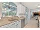 Bright kitchen featuring granite counters, stainless appliances, and white cabinets, with a large window view at 4063 Ligustrum Dr, Palm Harbor, FL 34685