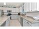Modern kitchen featuring granite countertops, stainless steel appliances and white cabinets with tile backsplash at 4063 Ligustrum Dr, Palm Harbor, FL 34685