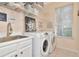 Well-lit laundry room with stainless steel sink, white appliances and storage shelves at 4063 Ligustrum Dr, Palm Harbor, FL 34685
