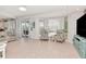 Spacious living room with tile floors, large windows, and sliding glass doors to the patio at 4063 Ligustrum Dr, Palm Harbor, FL 34685