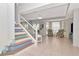 Bright living room with a unique staircase, tile flooring, and access to the outdoor pool area at 4063 Ligustrum Dr, Palm Harbor, FL 34685