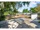 Exterior view of a backyard featuring mature trees and a large concrete slab at 4112 Alafia Blvd, Brandon, FL 33511