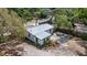 Exterior home elevation showcasing a metal roof, partial fencing, and a spacious driveway at 4112 Alafia Blvd, Brandon, FL 33511
