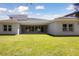 Well-manicured backyard with a covered patio and large sliding glass doors for indoor-outdoor living at 4517 Foley Grove Dr, Valrico, FL 33596