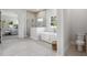Luxurious bathroom boasts a standalone tub, glass-enclosed shower, and modern tile flooring at 4517 Foley Grove Dr, Valrico, FL 33596