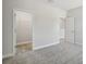 This empty bedroom has neutral carpeting and opens to a walk-in closet and hallway at 4517 Foley Grove Dr, Valrico, FL 33596
