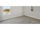 Neutral empty room with plush carpeting and views to the outdoors from two large windows at 4517 Foley Grove Dr, Valrico, FL 33596